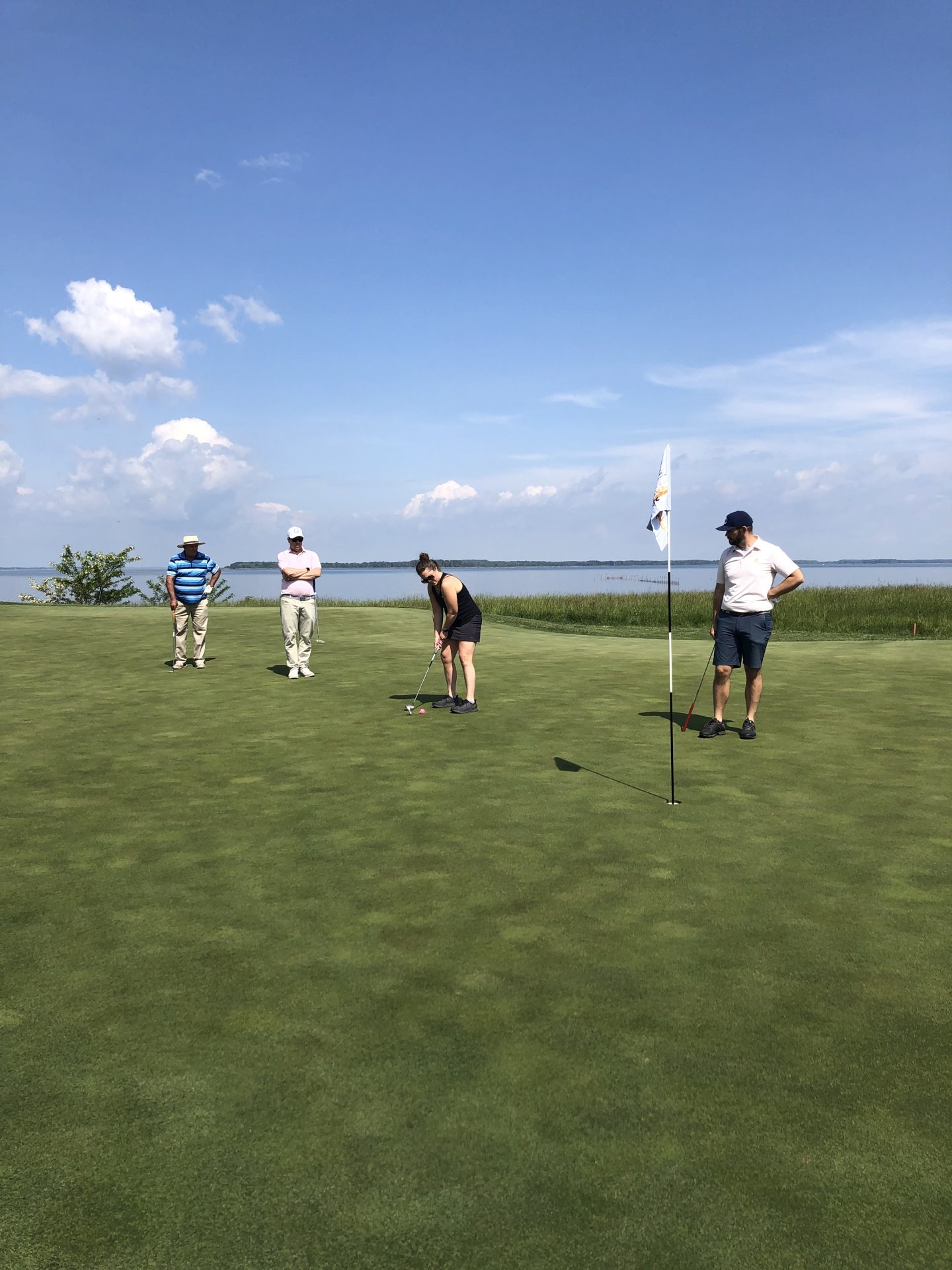 Golfers putting a gold ball during Tee it Up for The Arc