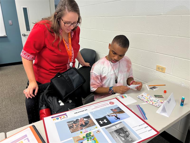 Sara helping a student prepare his vison board for his IEP and back to school