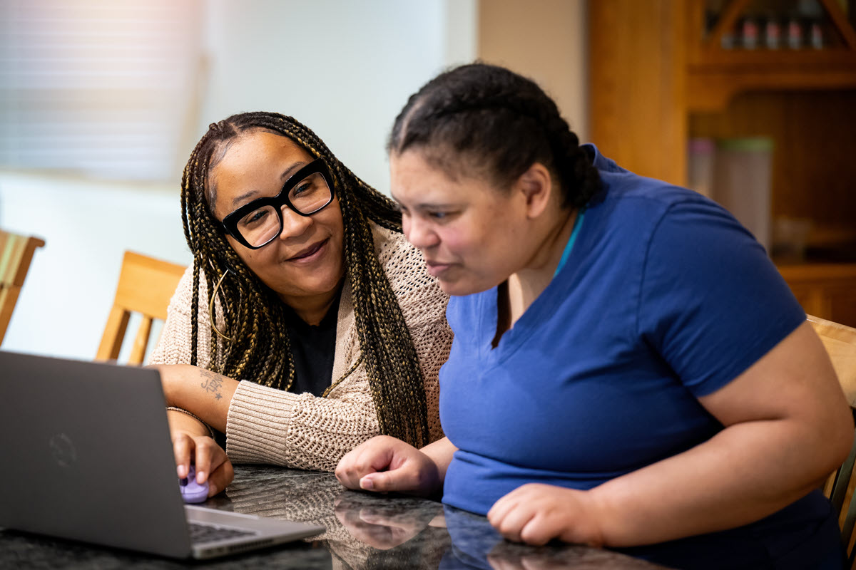 LPN DSP sitting at a table with a person she supports