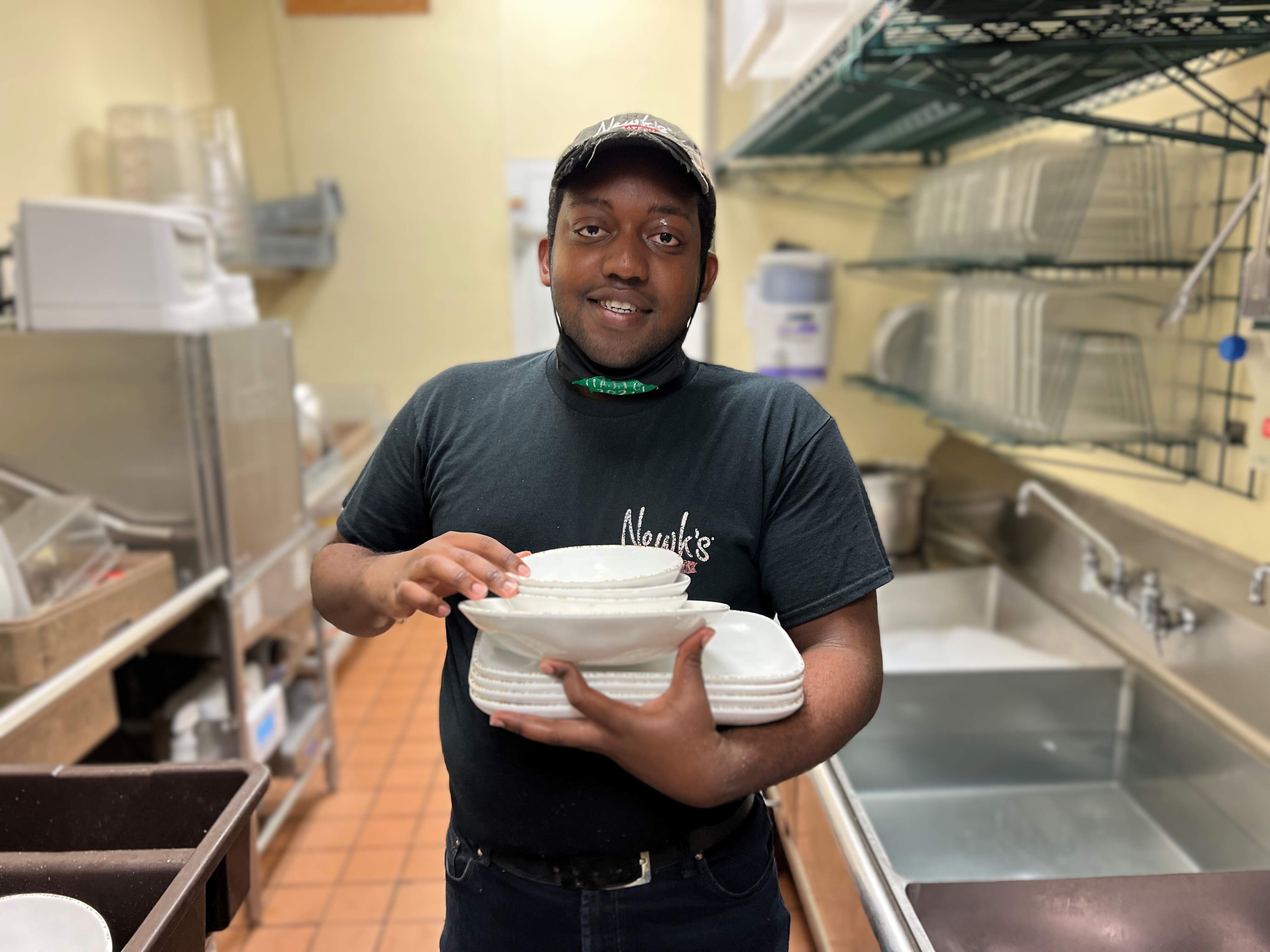 Jamal standing in Newk's kitchen where he works during October is National Disability Employment Awareness Month