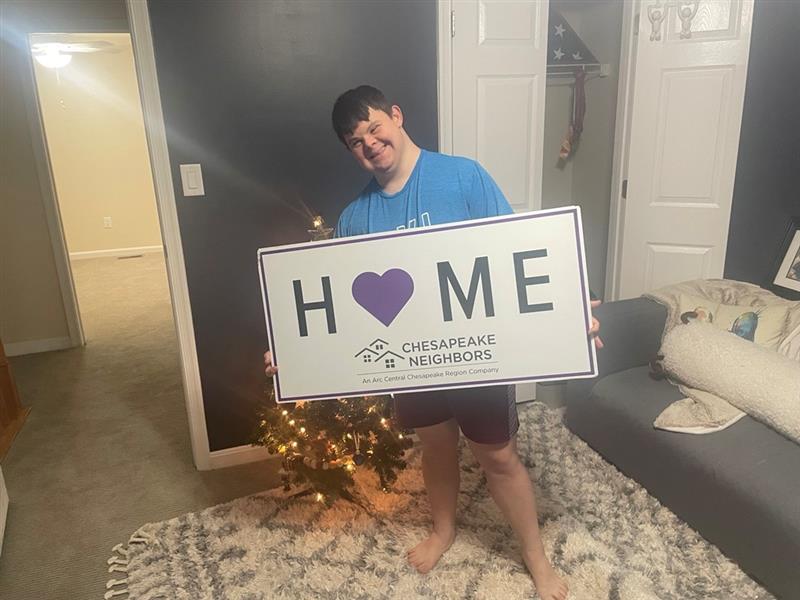 Noah holding a sign that welcome home